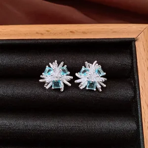Vista dettagliata di orecchini a lobo a fiore in argento con pietre di zircone blu