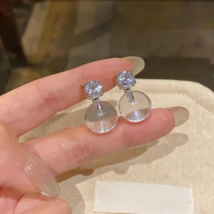 Detailed macro view of French style clear resin ball stud earrings with sparkly rhinestone
