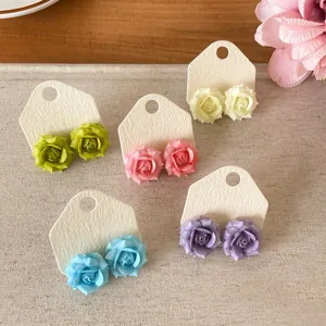 High-quality detailed view of colorful rose flower stud earrings in five soft pastel shades