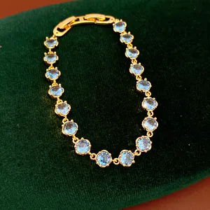 Detailed shot of 18k gold-plated bracelet with round light blue cubic zirconia stones
