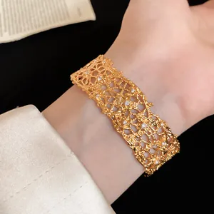 Close-up of golden lace texture cuff bracelet with shimmering small rhinestones
