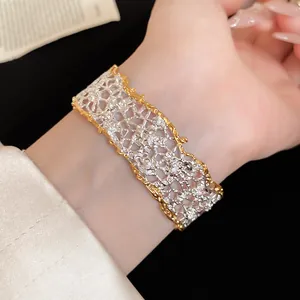 Close-up detail of an elegant two-tone lace texture open bracelet with shimmering diamonds