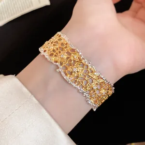 Close-up of gold and silver lace textured cuff bracelet with sparkling crystals