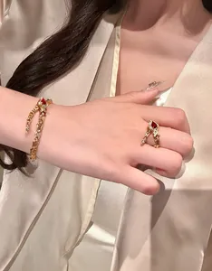 Close-up of vintage gold snake bone bracelet and pigeon blood red gemstone ring