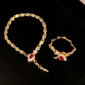 Luxury gold snake bone jewelry set with pear-shaped red gemstones and crystal accents