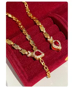 Close-up of vintage gold-plated snake chain jewelry with pigeon blood red gemstones
