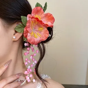 Elegant pink fabric flower hair clip with long floral tassels worn by an Asian model