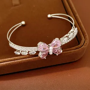 Elegant silver-toned open bangle featuring a pink zircon butterfly and pearl accents
