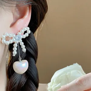 Elegant pearl bow-knot stud earrings featuring a romantic heart-shaped drop and zircon