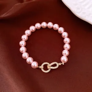 Elegant pink pearl bead bracelet with a gold-toned sparkling zircon clasp closure