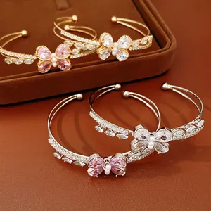 Close-up detail of double-layer zircon butterfly open cuff bracelets in gold and silver.