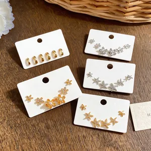 Detail view of various zircon starfish and flower earring sets on display cards