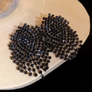 Detailed macro shot of black rhinestone mesh fringe earrings with silver needle posts