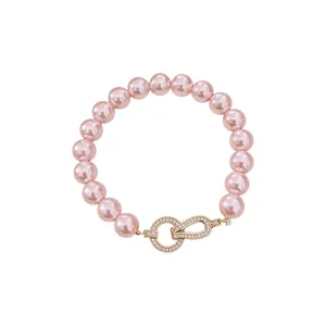 Elegant pink pearl bracelet featuring a crystal-encrusted gold circle clasp.