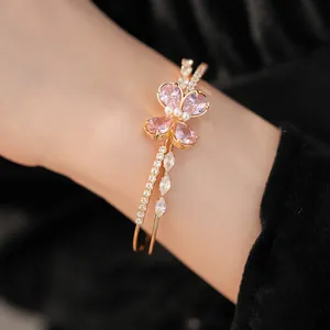 Close-up detail of double-layered gold bangle with pink zircon butterfly