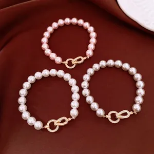 Detail shot of three elegant pearl bracelets with gold zircon link clasps