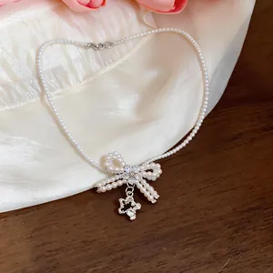 Vista dettagliata di un'elegante collana girocollo di perle con fiocco di zirconi e ciondolo