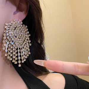 Close-up showing the intricate detail of sparkling rhinestone tassel drop earrings on model