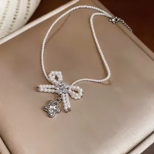 Dettaglio di una collana di perle in zircone in stile francese con ciondolo a fiocco e fiore