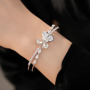 Close-up detail of silver double-layer cuff bracelet with sparkling crystal butterfly charm