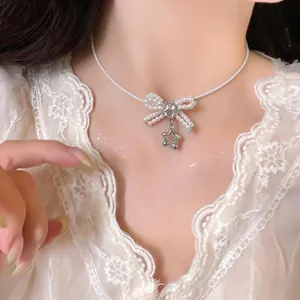 Dettaglio di una collana di perle stile francese con pendente a fiocco e ciondolo stella