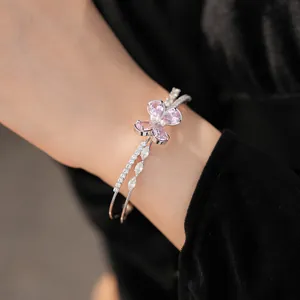 Detail view of pink butterfly zircon bangle with elegant double-layer cross design