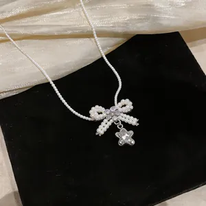 Dettaglio collana di perle con fiocco in zircone e ciondolo a stella brillante