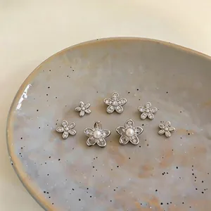 Detailed view of silver flower stud earrings set with pearls and zirconia