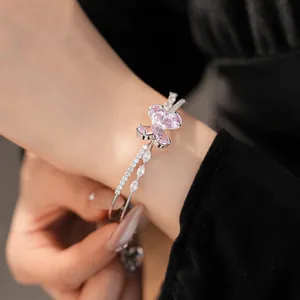 Detail shot of a stunning double-layered butterfly zircon bangle in silver and pink