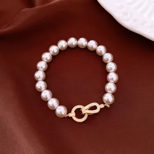 Detail view of a vintage pearl bracelet with a sparkling zircon-encrusted gold clasp.