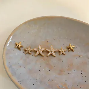 Detailed macro view of gold-plated starfish stud earrings set with sparkling zircons