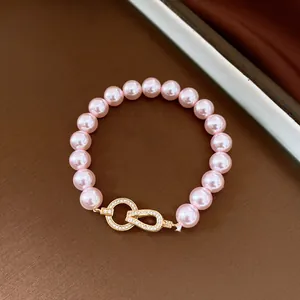 Detailed view of elegant pink pearl bracelet featuring a sparkling zircon horseshoe clasp