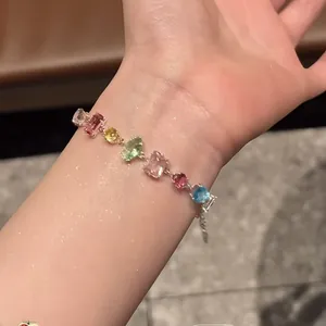 Vue détaillée d'un bracelet en zircon multicolore avec diverses formes de gemmes au poignet