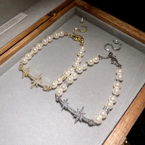 Close-up detail of starburst zircon and pearl bracelets in a wooden jewelry box.