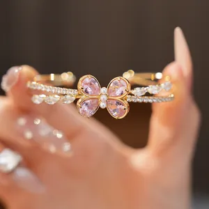 Detail of a luxury gold double-layer bangle with a sparkling pink crystal butterfly design