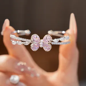 Close-up of pink zircon butterfly bangle with pearl details and shimmering stones