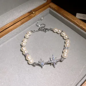 Close-up of 18k gold plated star pearl bracelet with shimmering zircons in a velvet gift box