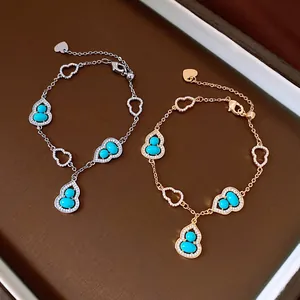 Dettaglio di bracciali a forma di zucca hulu con pietre turchesi e zirconi dorati