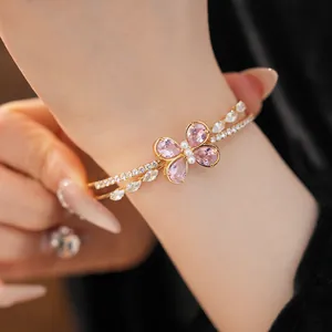 Close-up of elegant double-layer gold bangle with pink zirconia flower centerpiece