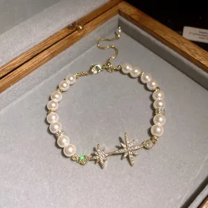 Close-up of pearl bracelet featuring sparkling 18k gold plated zircon star charms