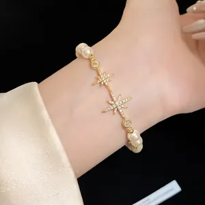 Close-up of elegant 18k gold plated bracelet with zircon stars and white pearls.