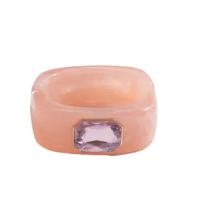 Großer rosa marmorierter Resin-Armreif mit einem markanten, rechteckigen Edelsteinbesatz.