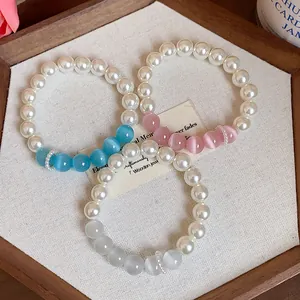 Close-up view of three elegant pearl bracelets featuring colorful cat-eye stone beads.