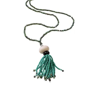 Ethnic style long green glass bead necklace with resin beads and beaded tassel detail