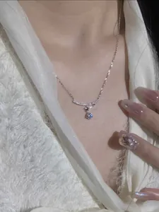 Detailed view of a silver necklace with curved bar and sparkling zircon pendant