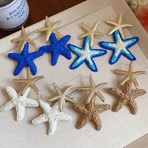 Elegant resort style raffia starfish earrings with metallic gold starfish studs