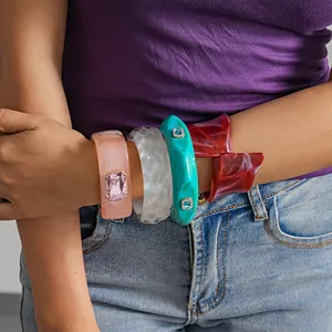 Detailansicht von klobigen Harz-Armreifen mit unregelmäßigen Formen und Strasssteinen.