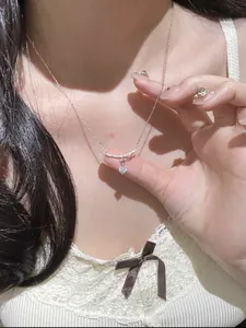 Close-up of delicate silver necklace featuring a sparkling zircon flower pendant
