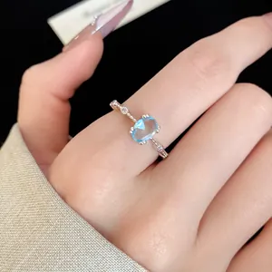 Gros plan d'une élégante bague en argent avec un zircon ovale bleu clair détaillé