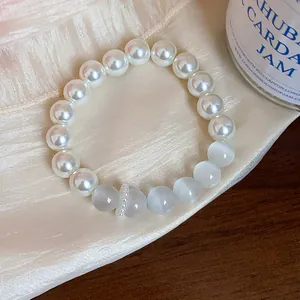 Macro view of elegant white pearl bracelet featuring cat's eye beads and spacer
